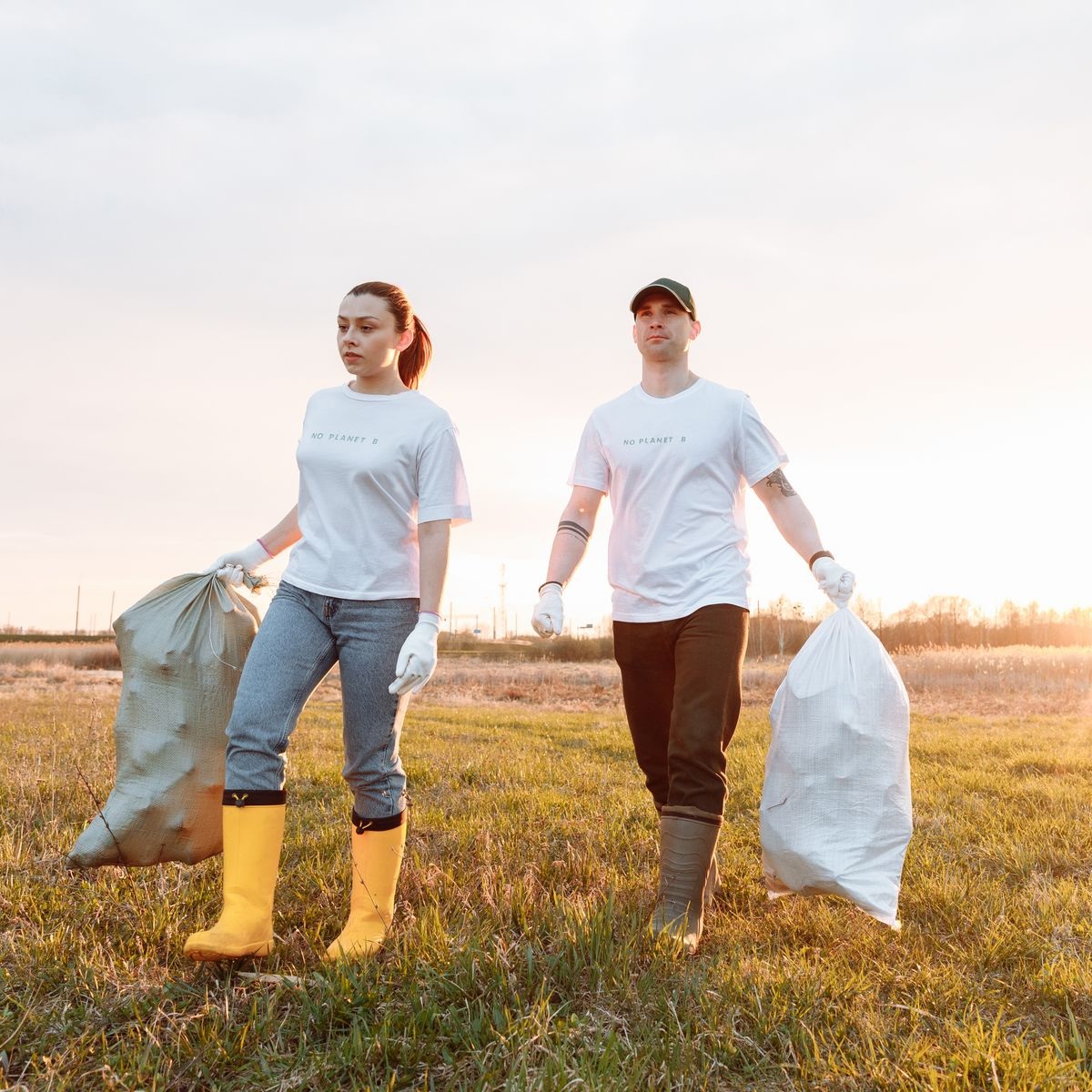 Cleanup workers carrying bags of collected rubbish for rubbish removal services near me